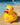 Yellow rubber kiwi bath toy with pink polka dots and flowers on a textured surface