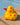 Yellow rubber kiwi bath toy with red hearts on a stone surface