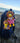 W.E.Kiwi and K.B.Kiwi mini plush toys attached to a blue bagpack on the beach in New Zealand